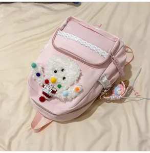 Sac à dos Ita rose avec poche avant transparente et bordure en dentelle, détail de chien en peluche.