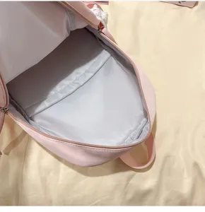 Vue détail de sac à dos rose en dentelle montrant la grande capacité et la doublure intérieure.
