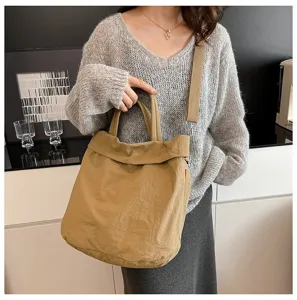 Λεπτομέρεια από casual καμβά tote τσάντα σε χακί χρώμα με ρυθμιζόμενο λουρί και χερούλια.