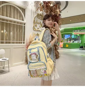Detail view of cute yellow student backpack with clear pocket design, lace trim and plush charm.