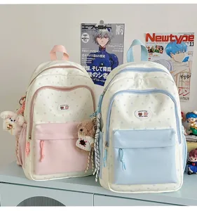 Cute contrast color backpack detail showing star pattern, front pocket, and plush bear pendant.