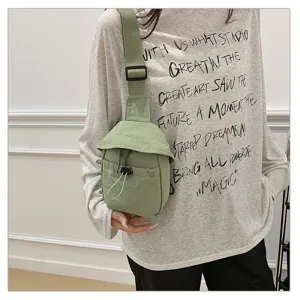 Close-up detail of lightweight green chest bag showing adjustable strap and drawstring pocket.