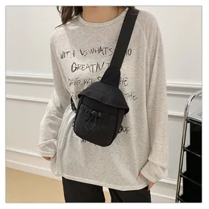 Detailed view of the casual black crossbody chest bag worn on model, showing durable fabric.