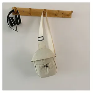 Casual minimalist beige crossbody chest bag hanging detail, lightweight outdoor daily wear.
