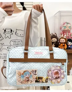 Graziosa borsa ita bag a pois azzurri con spillette anime e tasca trasparente.