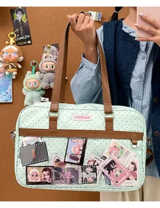 Borsa ita a pois verdi dotata di finestra trasparente e comodi manici in pelle marrone.