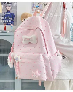 Détail de sac à dos rose à pois avec pendentif os en peluche et joli style japonais.