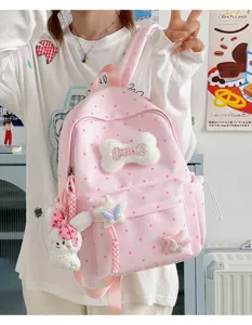 Sac à dos rose à pois mignon style ins japonais pour femmes avec os en peluche et pendentif.