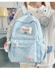 Charmant sac à dos bleu à pois pour femmes avec breloques en peluche os et étoiles doux.