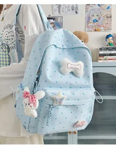Joli sac à dos bleu clair à pois avec adorables pendentifs en peluche pour un usage quotidien.