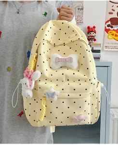 Détail du sac à dos jaune à pois avec pendentifs lapin et os en peluche, style mignon.