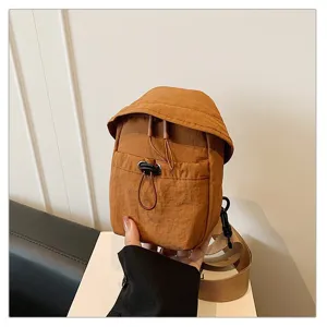 Detail view of a casual outdoor brown mini crossbody bag, showcasing drawstring design.