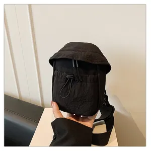 Close-up of black outdoor chest bag detail, showing adjustable drawstring and wide strap.