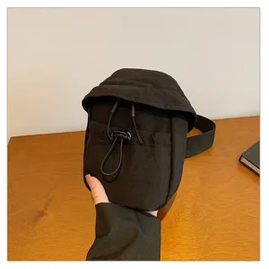 Casual black outdoor chest bag detail showing convenient drawstring closure and adjustable strap.