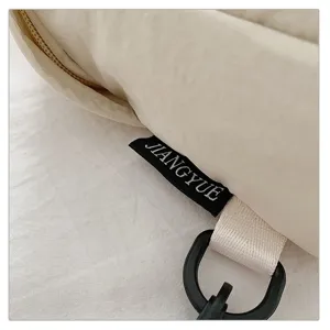 Detail shot of casual outdoor crossbody bag showcasing the brand tag, strap, and buckle.