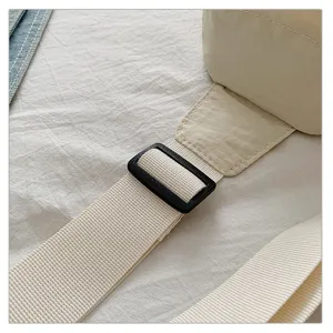 Close-up detail of adjustable strap and durable buckle on casual outdoor crossbody bag.