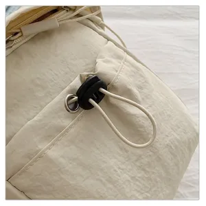 Close-up detail of casual outdoor chest bag drawstring toggle and metal hardware.