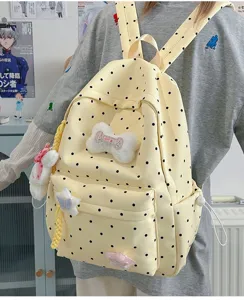 Vue détaillée du sac à dos à pois jaunes avec de charmants pendentifs en peluche.