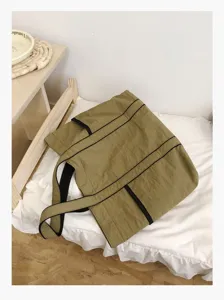 Detail view of large capacity khaki nylon tote bag, casual shoulder bag lifestyle shot.