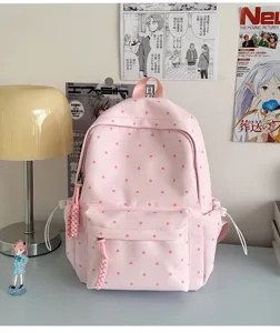 Détail de sac à dos rose à pois montrant un design mignon de cartable d'étudiant avec poche.
