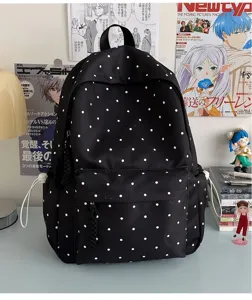Détail de sac à dos à pois noirs style ins japonais mignon avec poche avant et cordons latéraux.