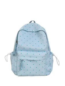 Gros plan sur le sac à dos bleu clair à pois, montrant la tirette tressée et la poche avant.