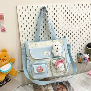 Cute polka dot canvas shoulder bag with large capacity, multiple pockets and plush toy pendants.