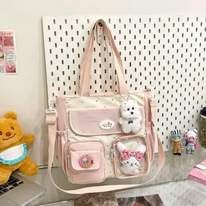 Detail view of cute polka dot canvas tote crossbody bag with lovely plush charms and pockets.