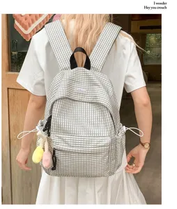 Vista dettagliata dello zaino a quadri casual, che mostra spallacci e pratiche tasche laterali.