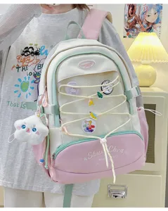 Dettaglio dello zaino stile giapponese carino, rosa pastello, bianco e verde con ciondoli.