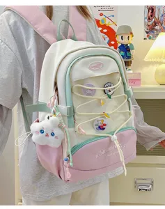 Dettaglio zaino carino stile giapponese con design a blocchi di colore pastello e spille.