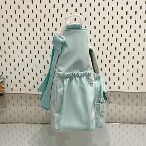 Cute mint green canvas crossbody bag side detail showing spacious pocket and adjustable strap.