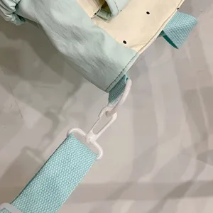 Detailed view of the cute polka dot shoulder bag strap, white plastic hardware buckle, and fabric.