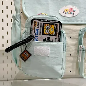 Close up detail of the cute polka dot backpack front pocket, featuring character decoration.