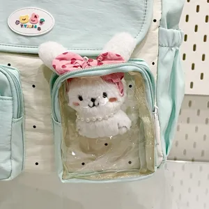 Detail view of sweet style polka dot crossbody bag with clear pocket and cute bunny plush toy.