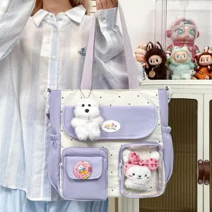 Cute polka dot canvas tote bag detail featuring multi pockets and adorable plush doll charms.