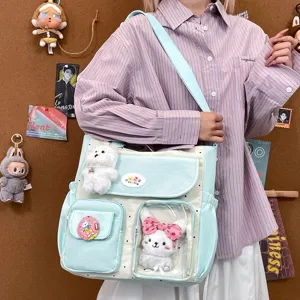 Cute polka dot canvas shoulder bag with clear front pocket and cute plush doll charms for girls.