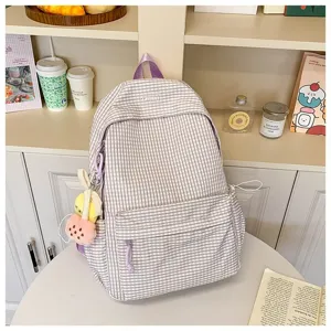 Vista dettagliata dello zaino a quadri viola con ciondolo in peluche e ampio spazio.