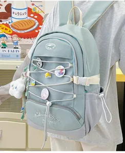 Zaino scolastico azzurro pastello stile giapponese con tasca in rete e spille per ragazze.