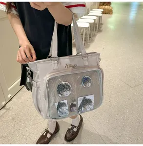 Vista dettagliata della borsa ita beige con tasca frontale in rete trasparente e spille anime.