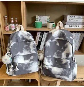 Dettagli dello zaino grigio tie dye, stile casual con ciondolo in peluche, perfetto per viaggi.