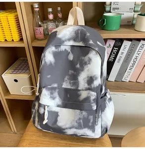 Dettaglio zaino tie-dye grigio con tasca frontale e morbida consistenza del tessuto.