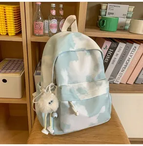 Dettaglio zaino tie-dye blu e bianco con grazioso ciondolo in peluche e comode tasche.