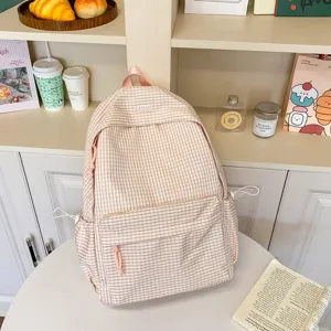Dettaglio zaino scolastico rosa a quadri chic, con tasca frontale e grande capienza.