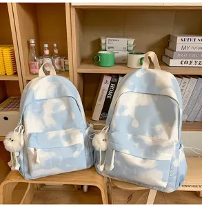 Vista dettagliata dello zaino da studente tie-dye nuvola blu con ciondolo in peluche e design laterale.