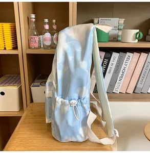 Vista dettagliata di uno zaino tie-dye blu e bianco con tasche laterali con coulisse e spallacci.