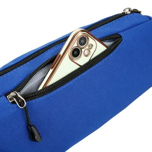Detailopname van blauwe heuptas met ritsvak en smartphone, met zicht op de duurzame stof.