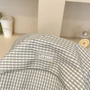 Primo piano dettagliato di uno zaino scozzese in stile coreano con etichetta logo in gomma e tessuto.