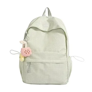 Dettaglio di uno zaino a quadri verde con ciondolo di peluche e grande capacita di stoccaggio.