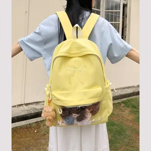 Dettaglio dello zaino ita giallo con finestra trasparente, grazioso ricamo fiocco e peluche.